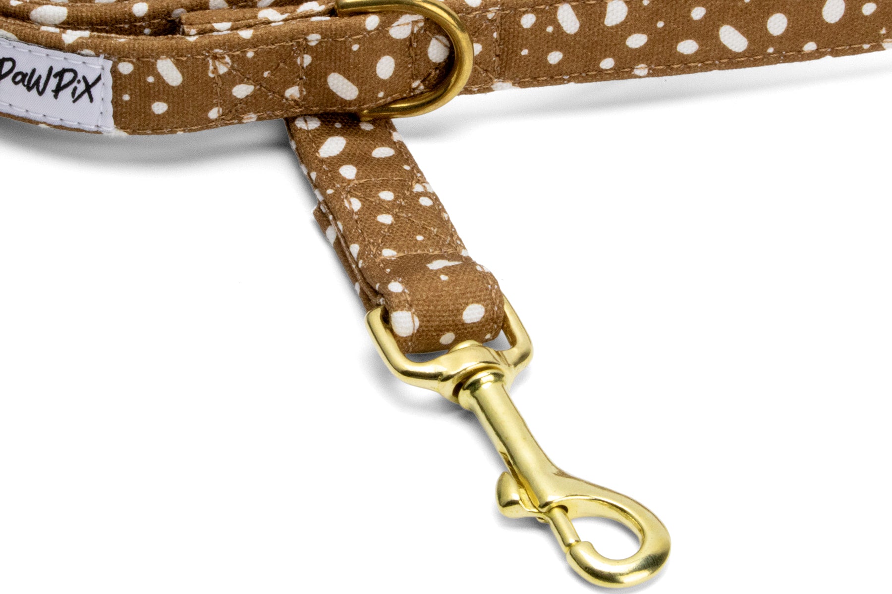 Gros plan sur le mousqueton couleur or de la laisse pour chien Freckles. Laisse avec un motif marron tacheté blanc