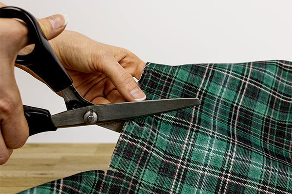 Gros plan sur la coupe aux ciseaux du tissu Nessie, motif carreaux tartan vert écossais
Design made in France et tissu OEKO-TEX®