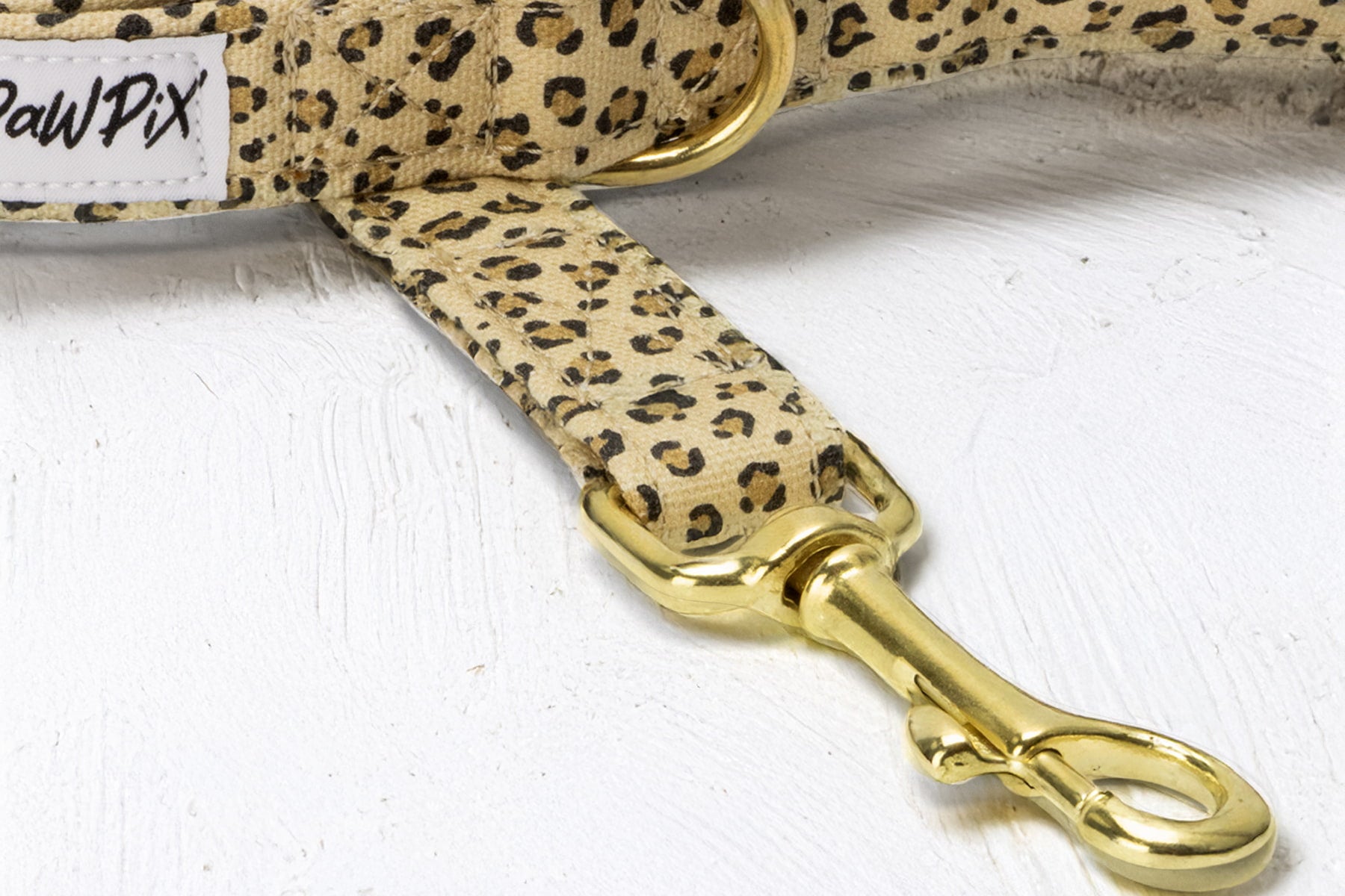 Gros plan sur le mousqueton de la laisse Leopaw de Pawpix au motif léopard. Le mousqueton est en laiton.