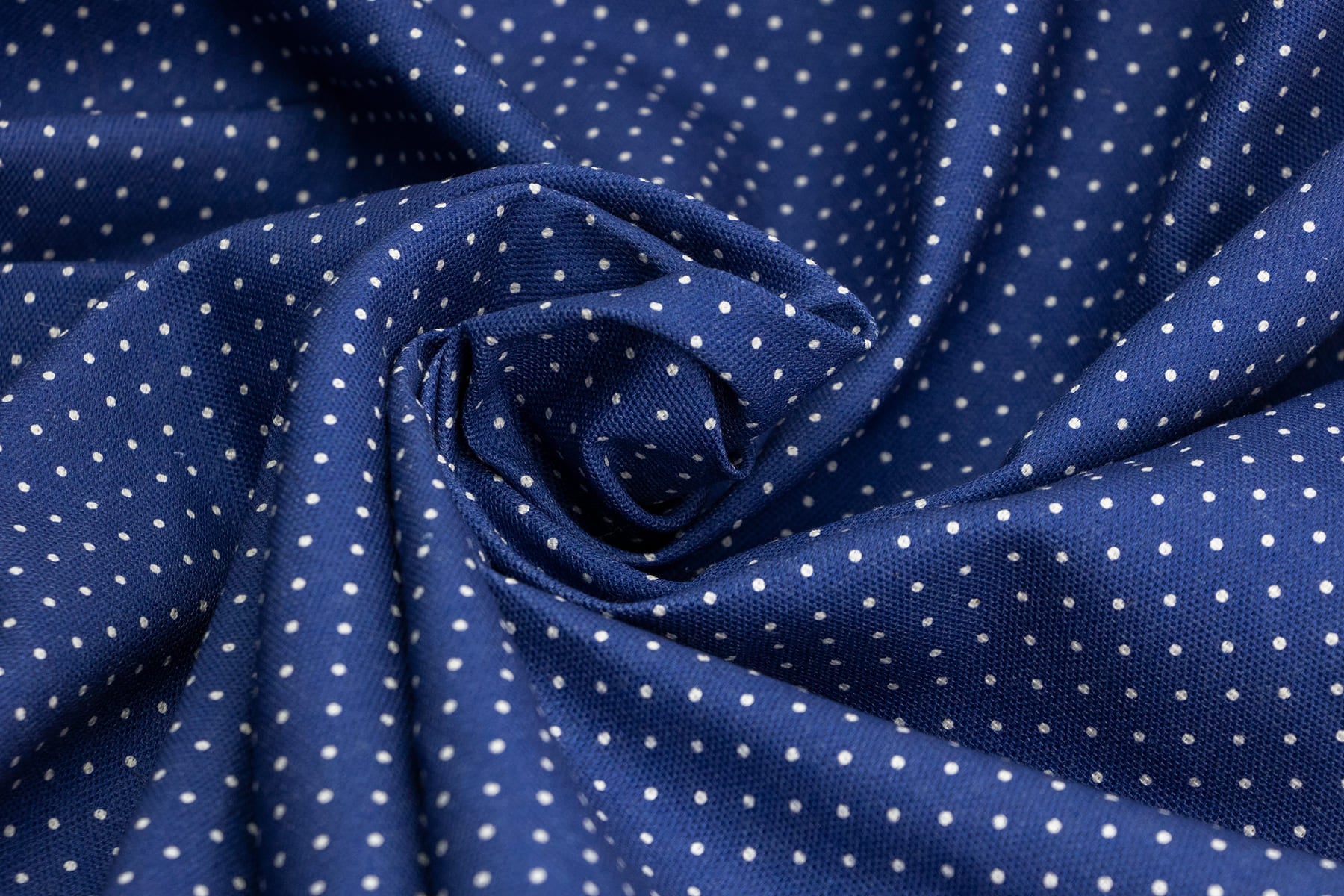 gros plan sur le tissu Polaris de PawPix. Des pois blancs sur un fond bleu marine