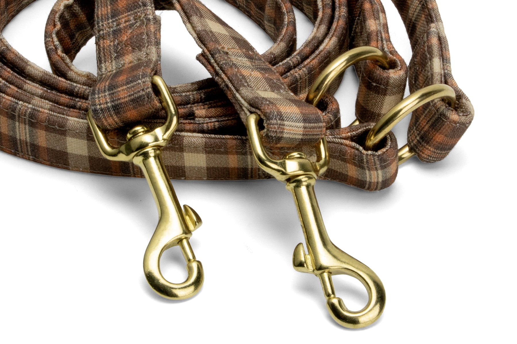 Gros plan sur les mousquetons de la laisse pour chien multipositions Scotty. Motif tartan marron, orange et mousquetons couleur or
