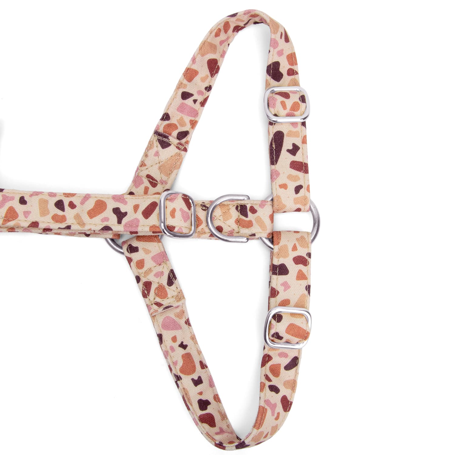 Gros plan de la boucle anti-traction du harnais en Y pour chien Pawpino et son motif terrazzo rose/marron. Les boucles sont couleurs or