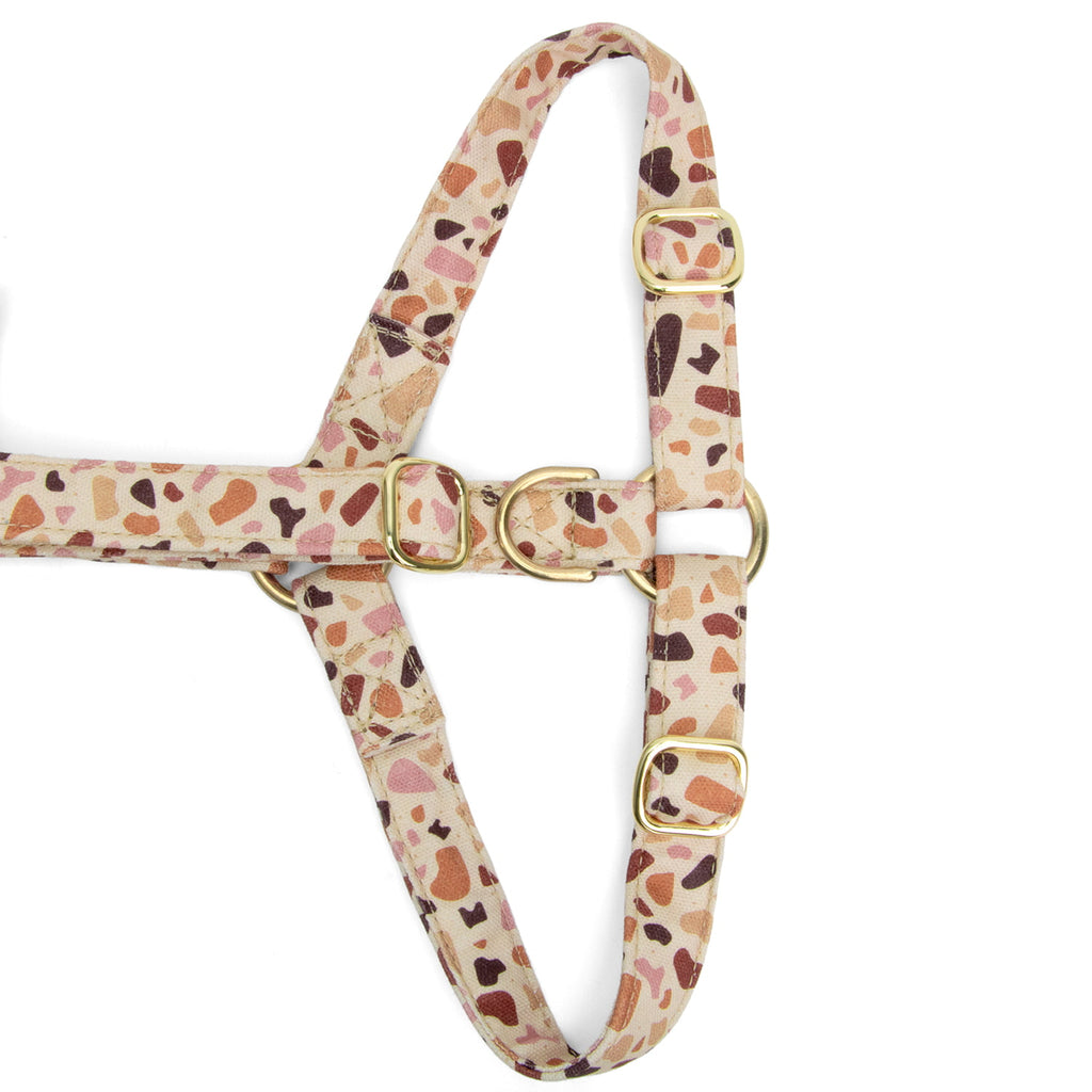 Gros plan de la boucle anti-traction du harnais en Y pour chien Pawpino et son motif terrazzo rose/marron. Les boucles sont couleurs or