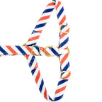 Gros plan de la boucle anti-traction du harnais en Y pour chien Pawtriote et son motif rayé bleu blanc rouge. Les boucles sont couleurs or 