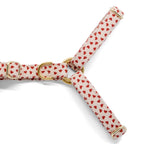 Gros plan sur la forme Y et la boucle anti-traction du harnais en Y pour chien My Valentine de Pawpix et son motif cœurs rouges sur fond beige. Le harnais possède des boucles couleur or