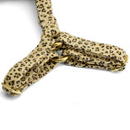 Gros plan ses les boucles du harnais pour chat Leopaw. Le harnais au motif léopard avec des boucles de réglage en or clair. 