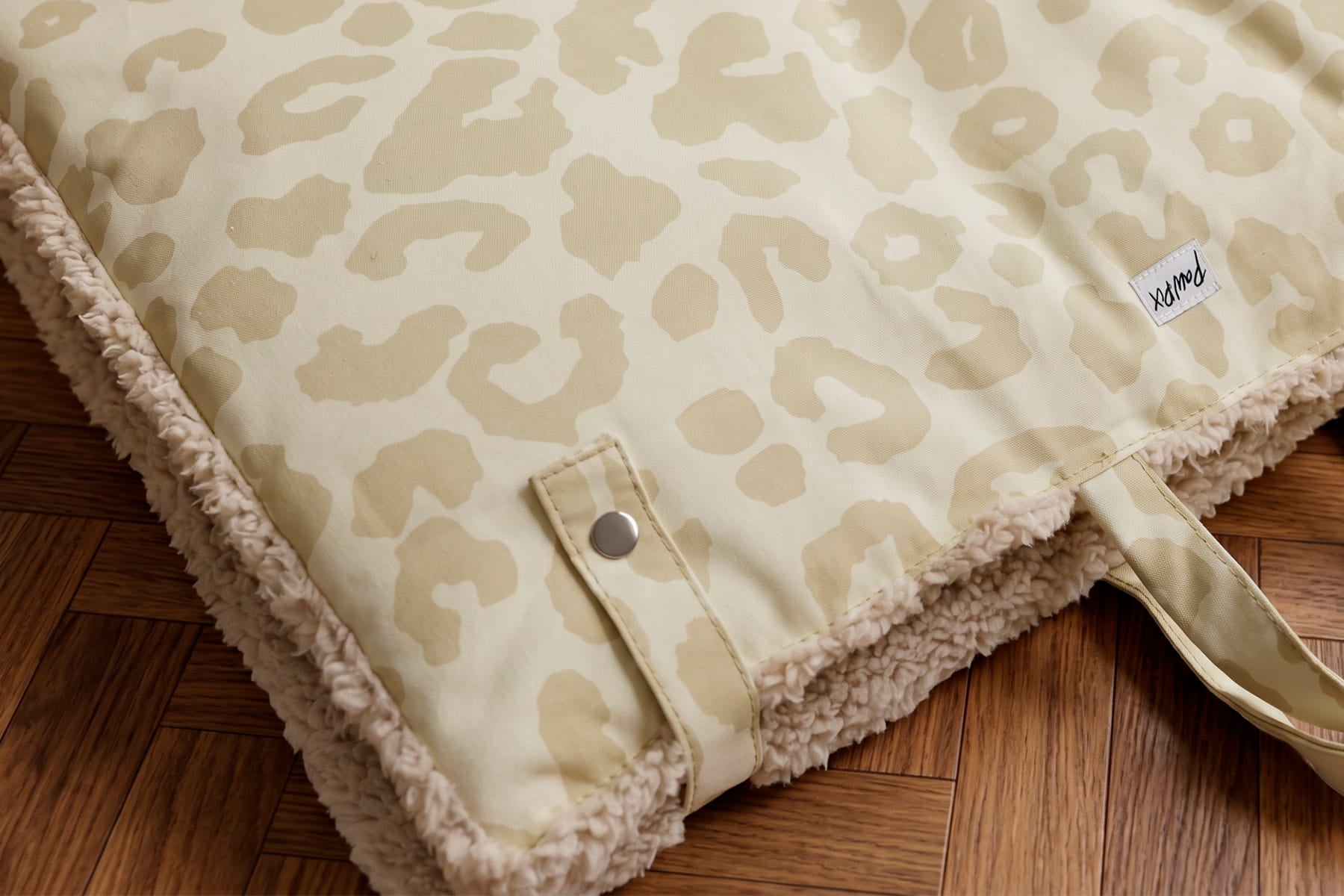 Gros plan sur les boutons pressions du tapis de voyage Cuddles de Pawpix pour chiens et chats. Les boutons permettent de refermer le tapis et de le transporter facilement