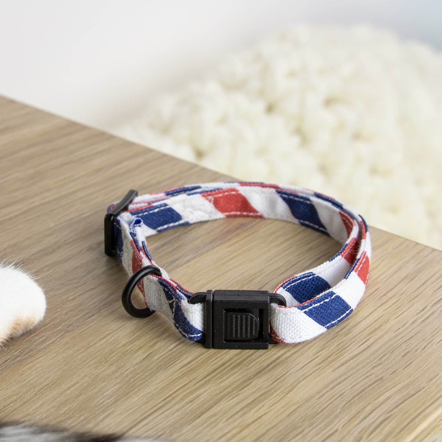 Gros plan sur le collier pour chat Pawtriote de PawPix au rayure tricolore bleu blanc rouge et avec sa boucle anti étranglement 