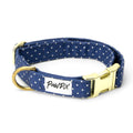 Collier pour chien Polaris. Design bleu marine avec des pois blancs. 
Bouclerie couleur or, avec un anneau en D, une boucle de serrage et une boucle clips pour fermer/ouvrir le collier