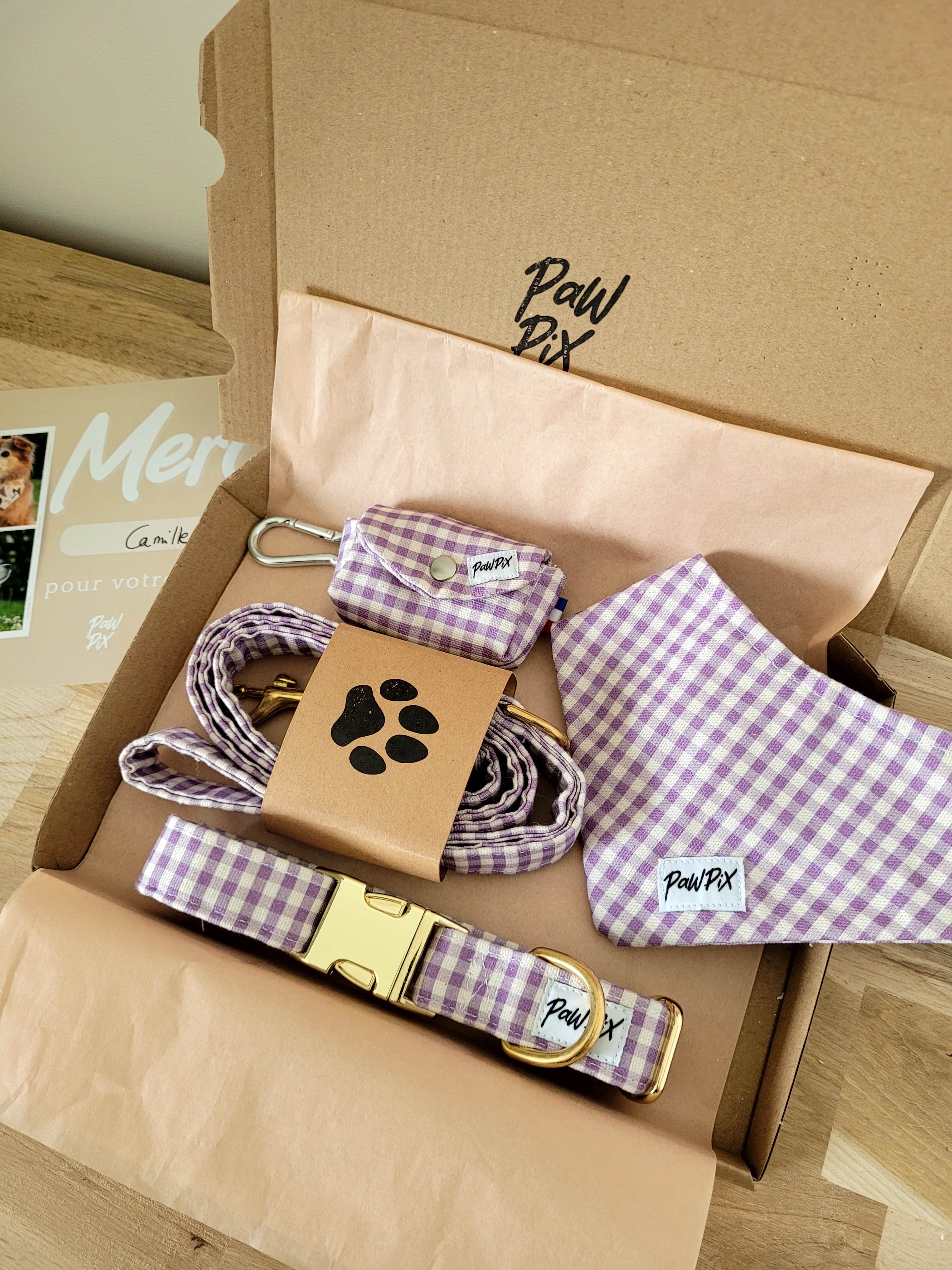 Carton d'une commande réalisée pour Camille avec les accessoires pour chien de la collection cigalou (motif vichy lavande). La commande comporte, un bandana, une pochette sacs à crottes, une laisse et un collier pour chien