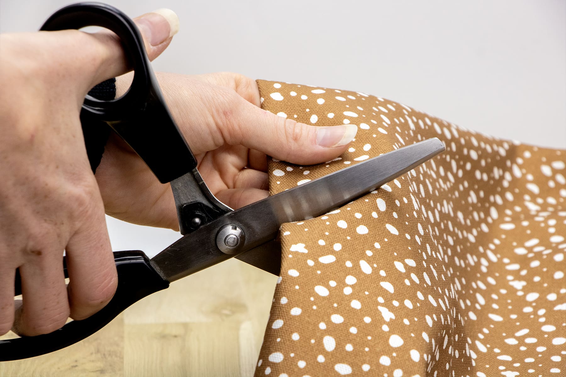 Gros plan de la coupe du tissu Freckles dans l'atelier Pawpix en France. Le tissu sert pour la confection des accessoires pour chiens et chats