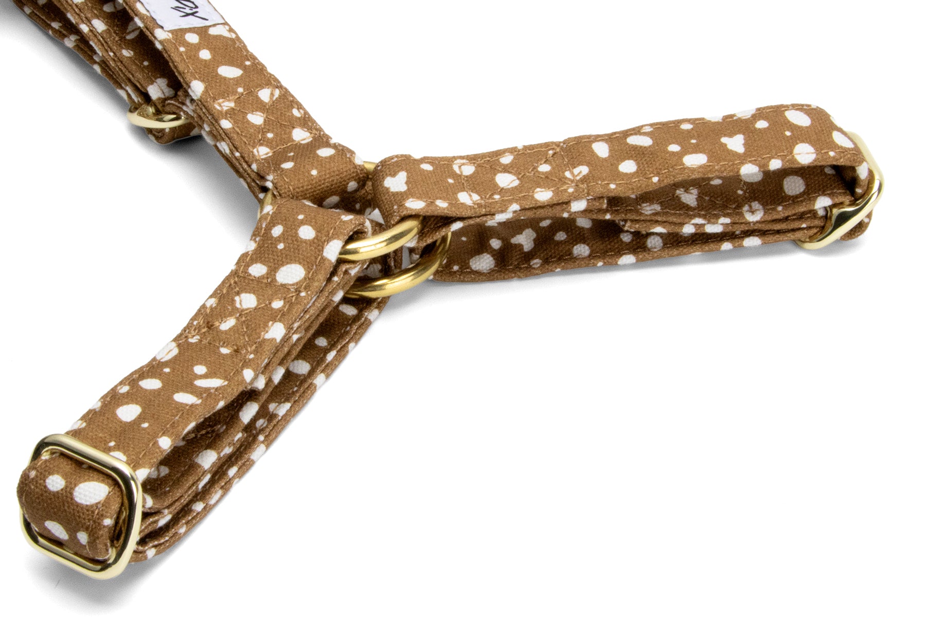 Gros plan des boucles de reglages du harnais en Y Freckles et son motif marron tacheté blanc. Les boucles sont couleurs or