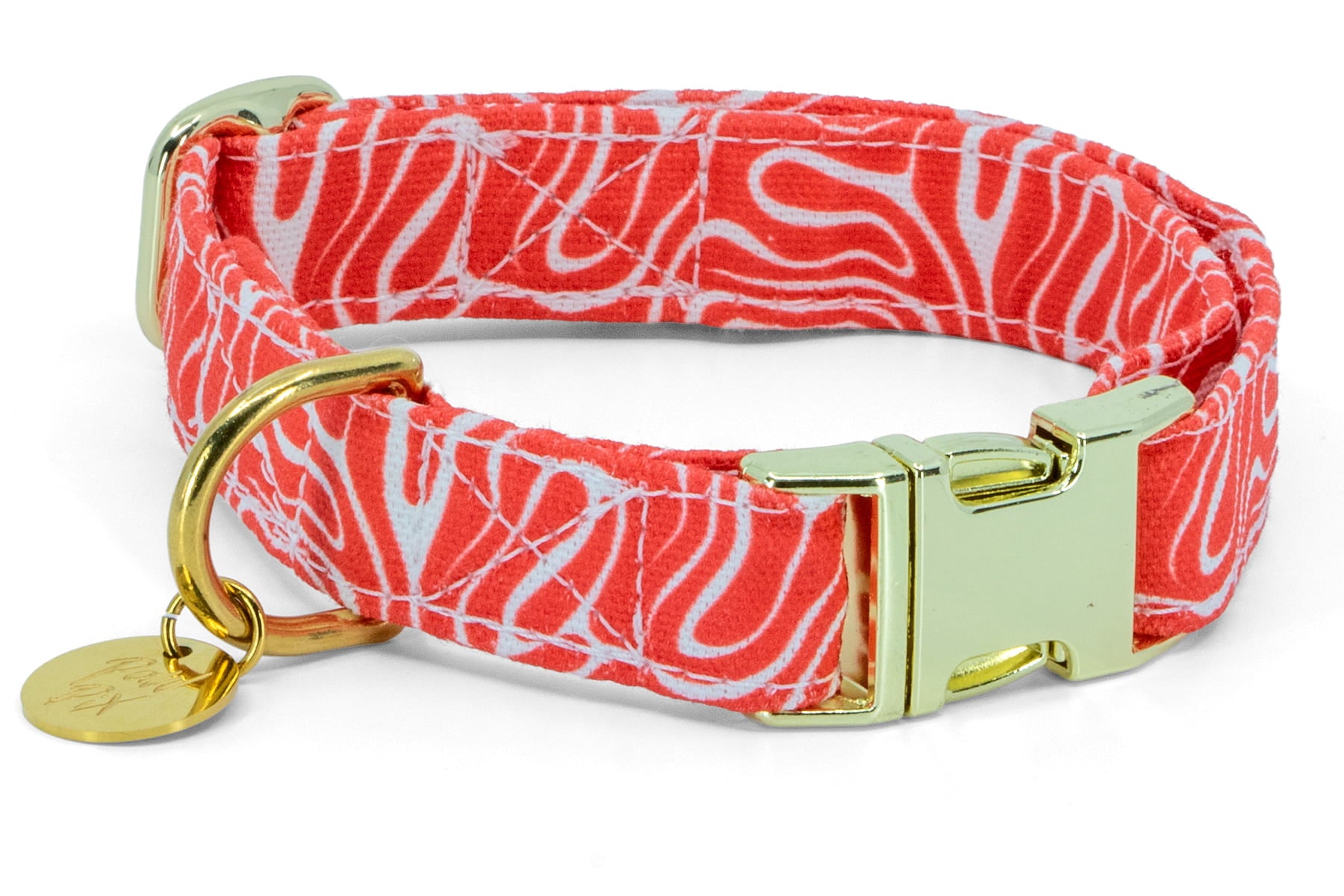 Gros plan des boucles couleur or du collier pour chien Cherry de Pawpix. Motif rouge et blanc wavy 