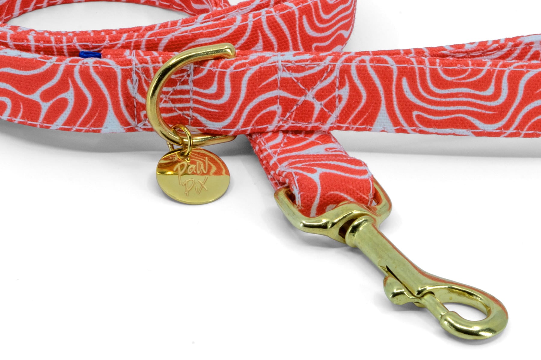 Gros plan du mousqueton et de l'anneau en D de la laisse pour chien et chat Cherrry de Pawpix. Le mousqueton et l'anneau en D sont de couleur or/laiton. Motif rouge et blanc wavy