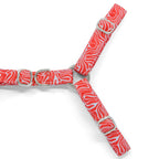 Plan rapproché de la boucle anti-traction du harnais en Y Cherry de Pawpix. La boucle est présente sur la partie poitrail du harnais et de couleur argent. Le harnais présente un motif rouge et blanc wavy