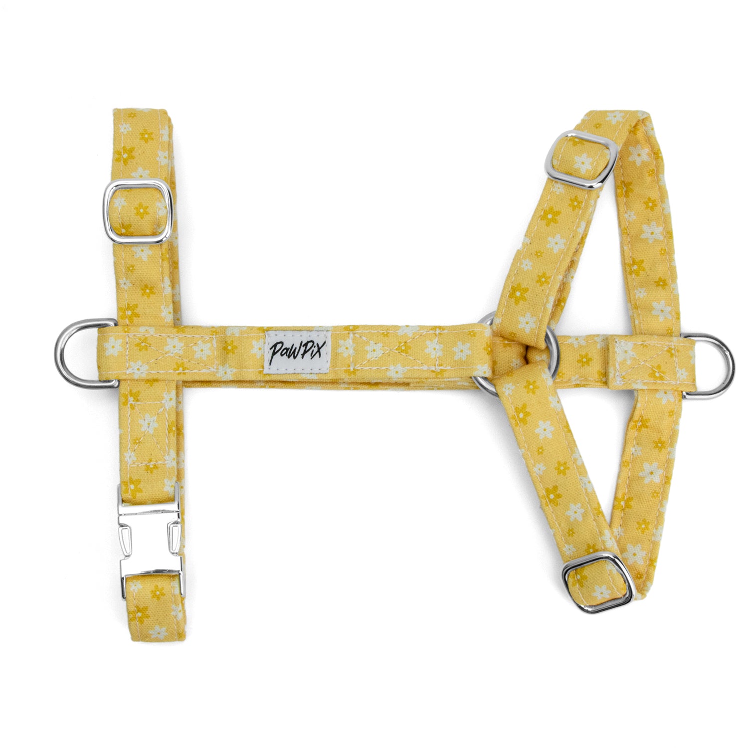 Harnais pour chien Peachy Daisies avec ses marguerites blanches et jaune sur fond couleur pêche. Les boucles et anneaux du harnais sont couleur argent.  Le harnais possède également un anneau anti-traction et une boucle ventral pour un harnais parfaitement réglé. 