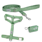 Kit pour chien comprenant un harnais en Y, une laisse et une pochette sacs à crottes. Le tout avec un design reprenant l'esprit nature blanc sur un fond vert avec des boucles argentés