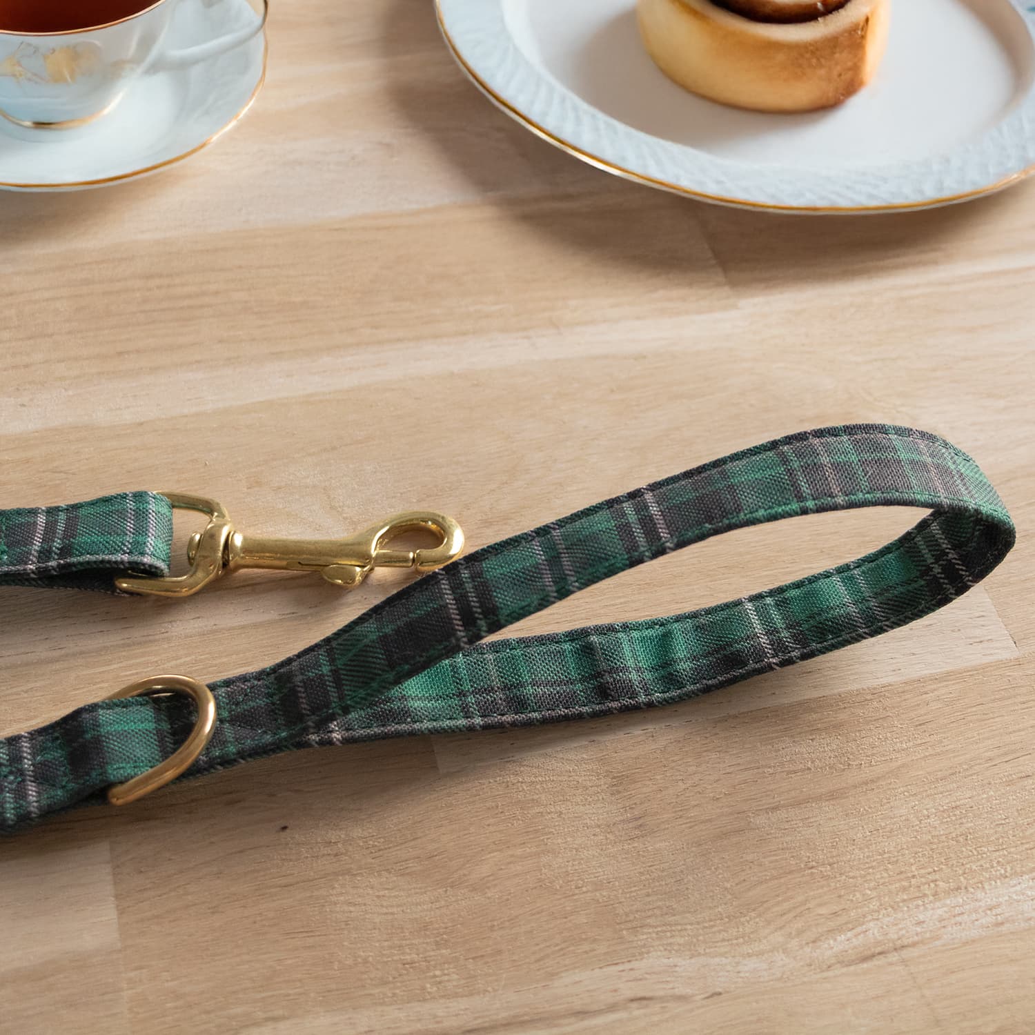 Extrémités de la laisse en tissu Nessie de Pawpix. Équipée d’un mousqueton et d’une anse confortable. Le design reprend le motif à carreaux tartan vert écossais