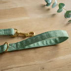 Extrémités de la laisse en tissu Topo de Pawpix. Équipée d’un mousqueton et  d’une anse confortable.  Le motif Topo reprend le design géométrique des cartes de montagnes, avec des lignes blanches sur un fond vert