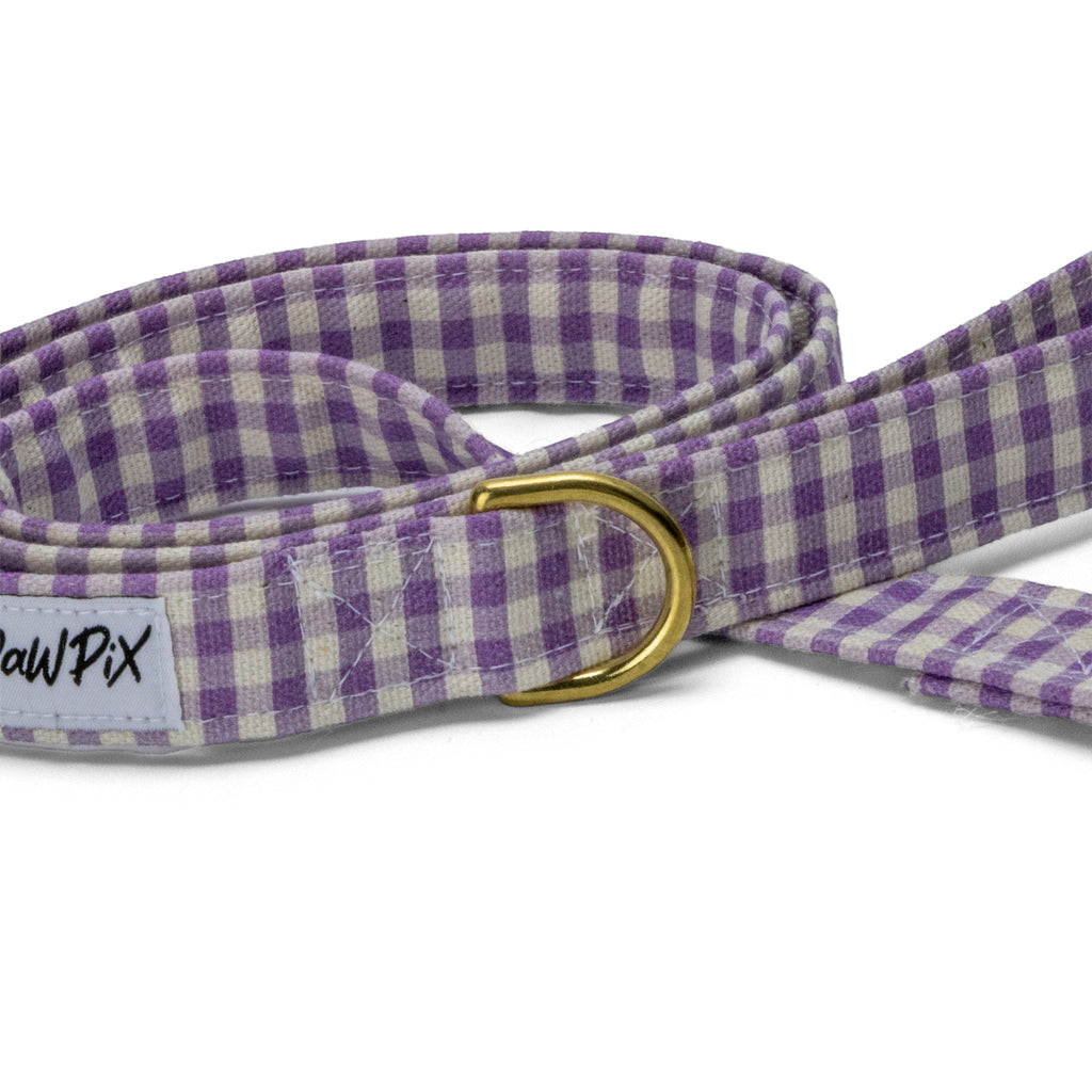 Gros plan sur l'anneau en D de la laisse Cigalou qui permet d'attacher différents objets pour les promenades. Motif vichy violet clair