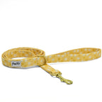 Laisse pour chien Peachy Daisies et son motif marguerites jaunes et blanches sur fond pêche. La laisse fait 1m20 et est équipé d'un mousqueton pour accrocher aux harnais ou collier ainsi qu'un anneau D pour accrocher une pochette sacs à crottes ou un porte balle. 