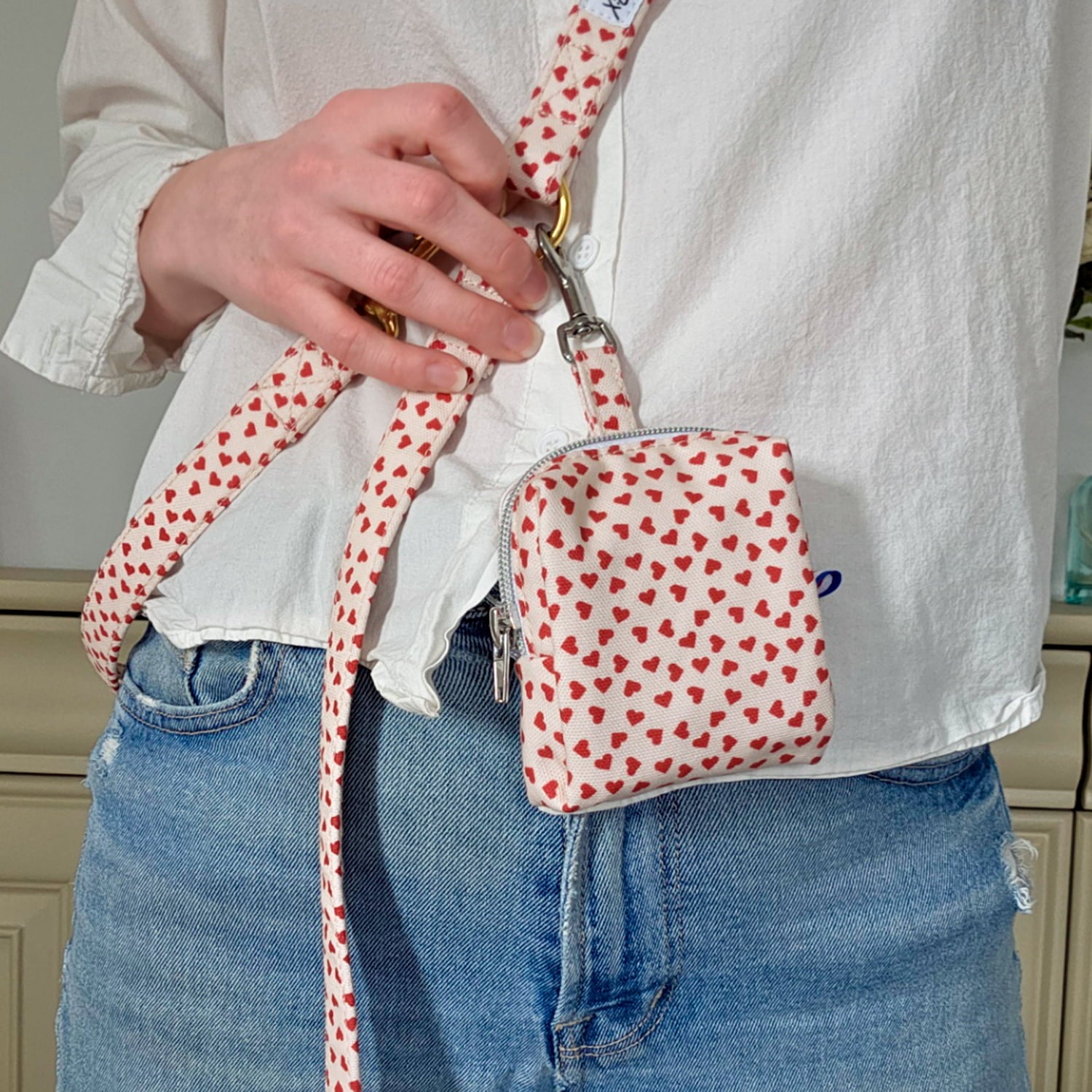 Gros plan de la mini sacoche pour chien My Valentine et son motif cœurs rouges, accrochée à la laisse multipositions My Valentine de Pawpix 