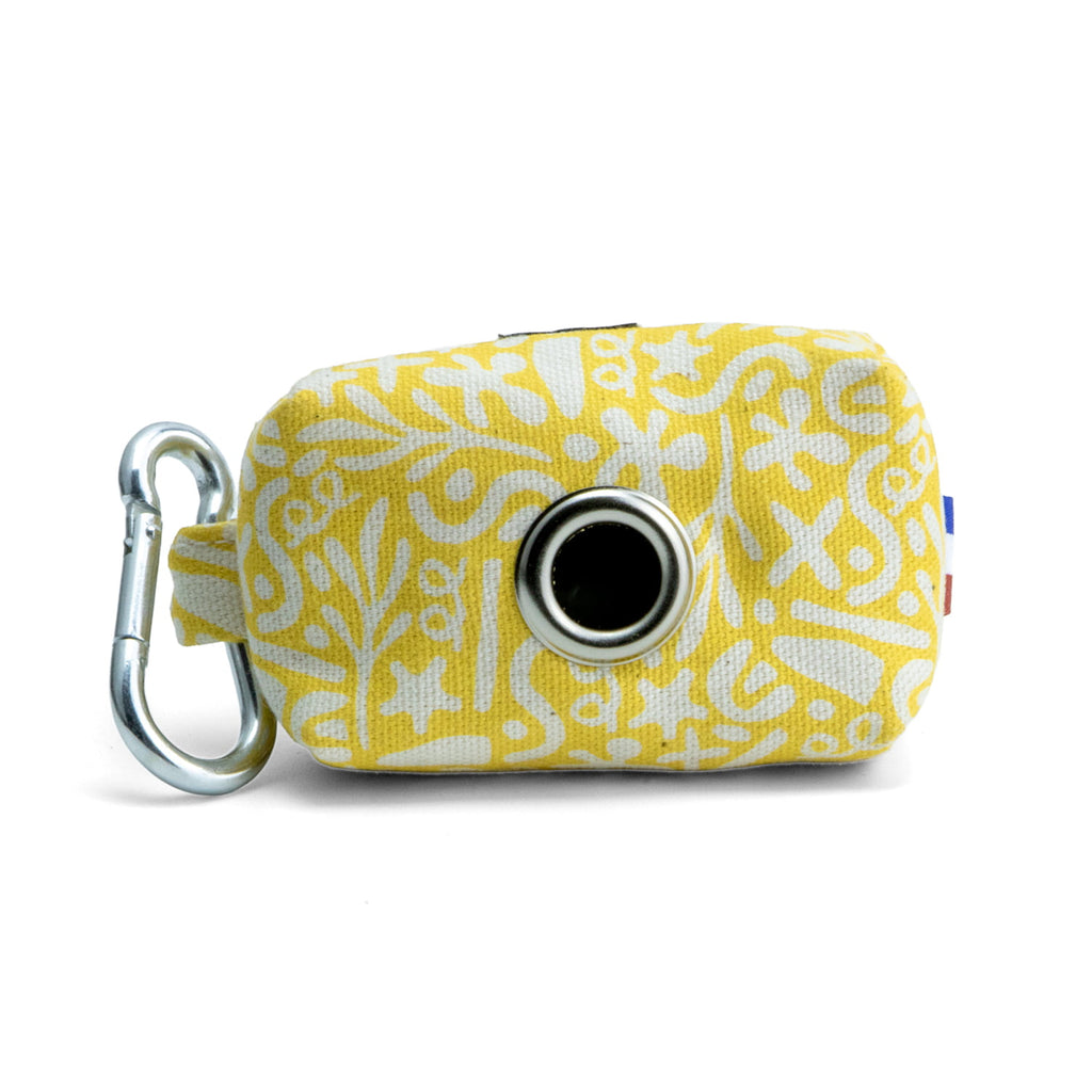 Arrière de la pochette sacs à crottes Seaside  avec son motif marin abstrait blanc sur fond jaune solaire. L'arrière de la pochette possède un œillet assez large pour passer les sacs à crottes, ainsi qu'un mousqueton pour accrocher la pochette à une laisse ou autre accessoire