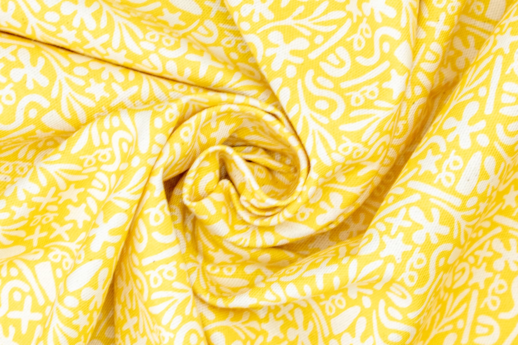 Gros plan sur le textiles Seaside avec son motif marin abstrait blanc sur un fond jaune solaire. Parfait pour l'été. 