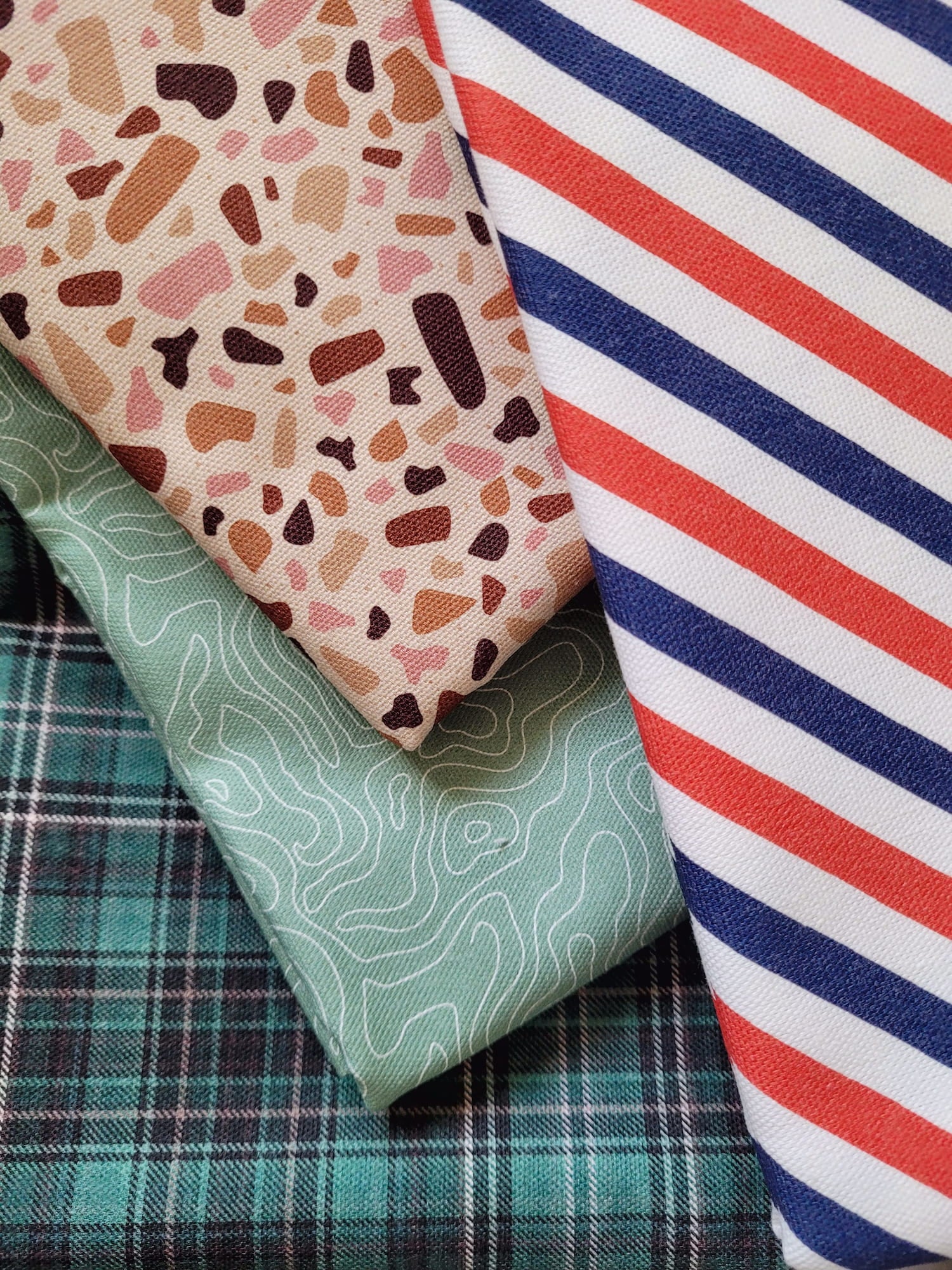 Tissu avec divers motifs : rayé tricolore, géométrique terrazzo et tartan écossais, et topographique pour la confection des accessoires PawPix