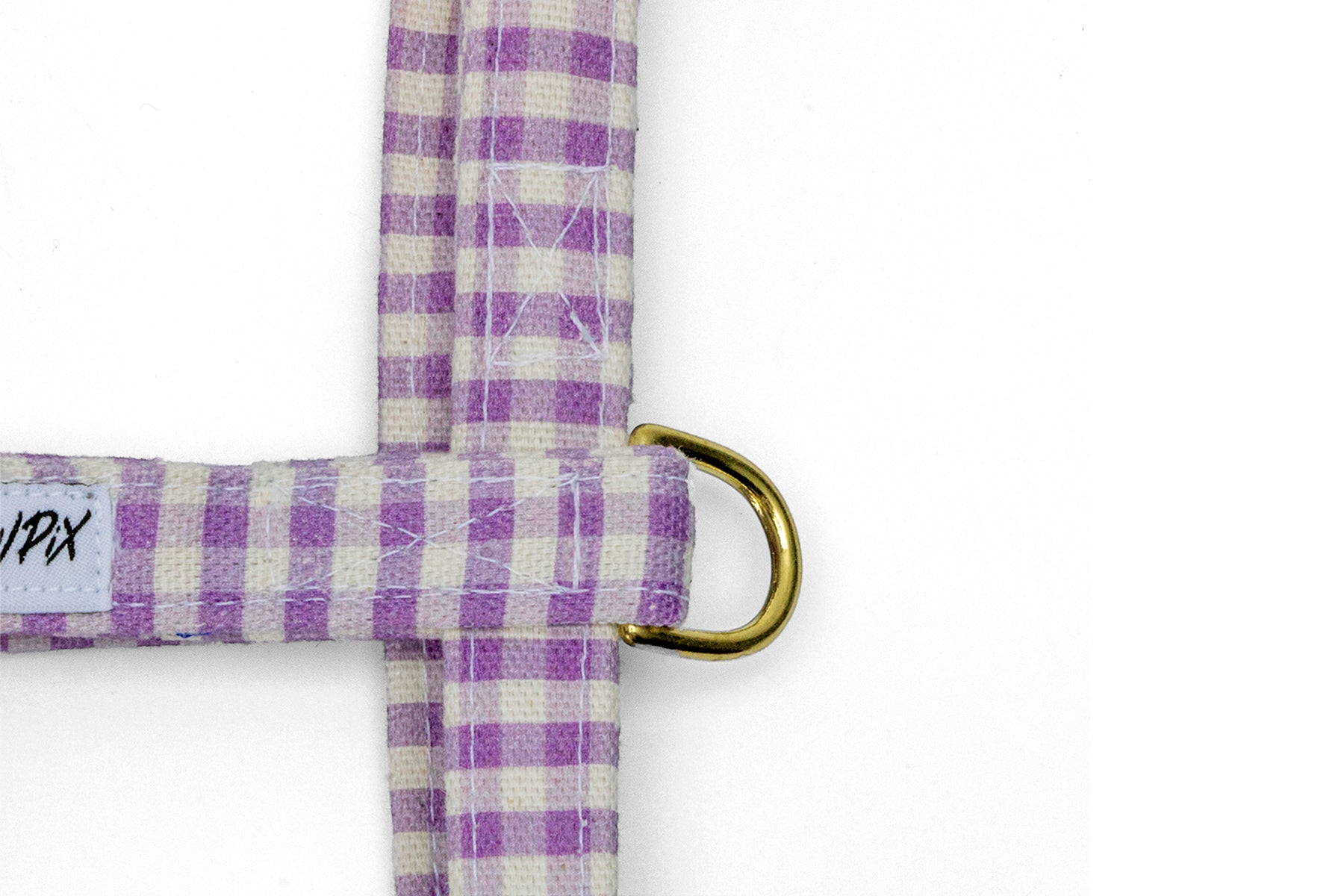 Gros plan sur l'anneau en D du harnais pour chat Cigalou qui permet d'attacher le harnais avec une laisse. Motif vichy violet clair